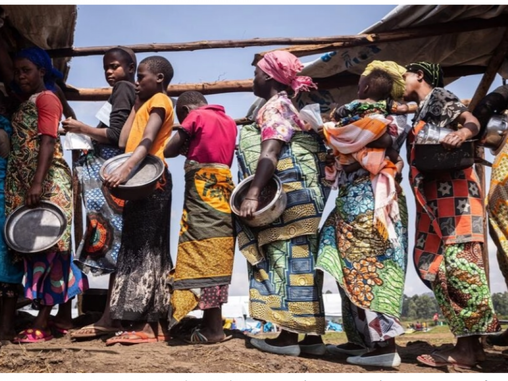 Des déplacés récemment arrivés du territoire de Rutshuru (Nord Kivu) attendent pour le déjeuner dans le camp de transit de réfugiés de Nyakabande, à Kisoro dans l'Ouganda, le 7 juin 2022. © badru Katumba / AFP