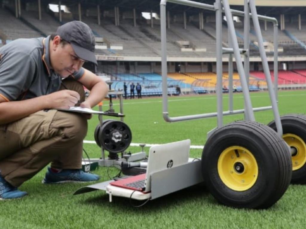 Un expert de la CAF inspectant l' eat de la pelouse du stade des Martyrs
