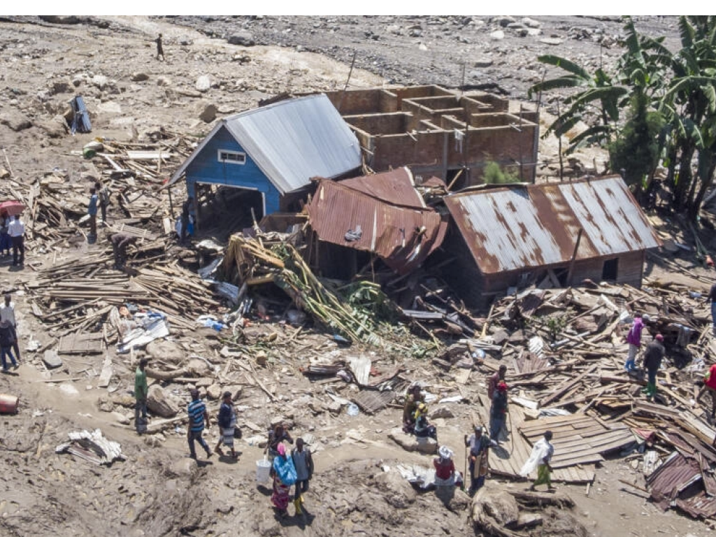 Des rescapés marchent parmi les débris après les inondations à Nyamukubi, dans le Sud-Kivu, 8 mai 2023. © Justin Kabumba / AP
