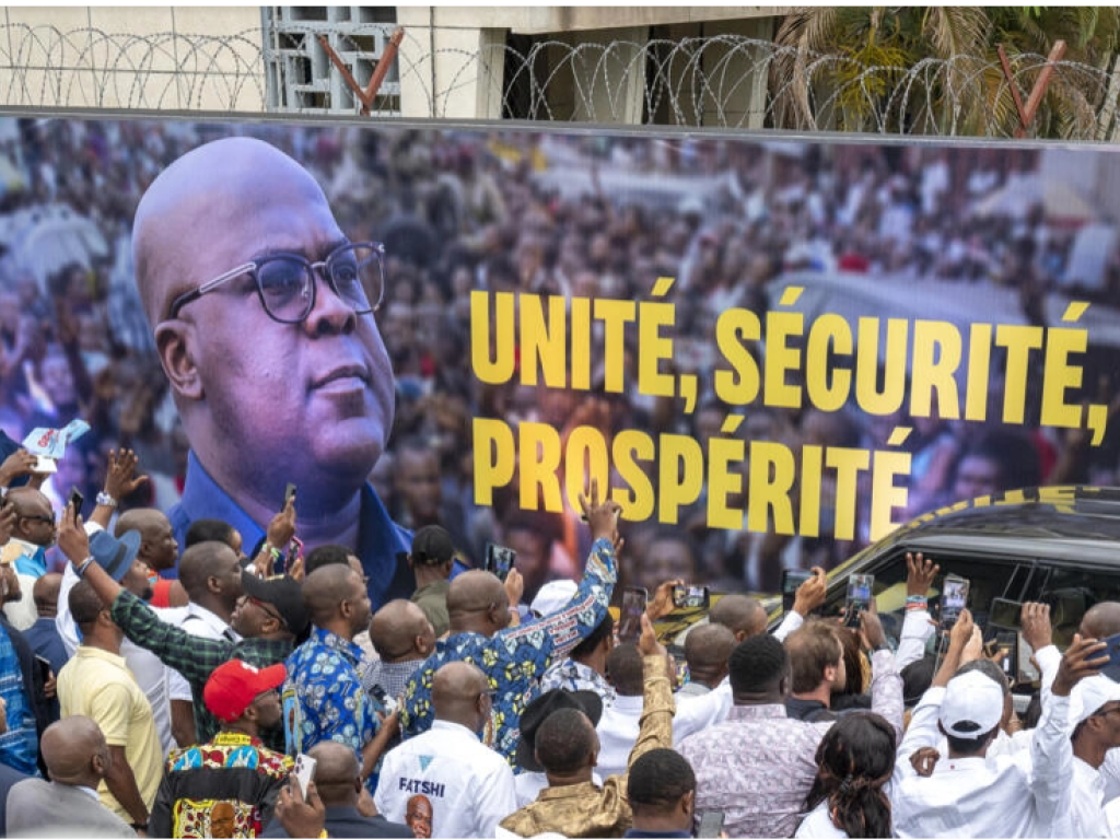 Des partisans saluant le président sortant de la République démocratique du Congo (RDC), Félix Tshisekedi, alors qu'il arrive dans son cortège avant l'annonce des résultats des élections au QG Fatshi 20, siège de sa campagne électorale, à Gombe, Kinshasa, le 31 décembre 2023. AFP - ARSENE MPIANA
