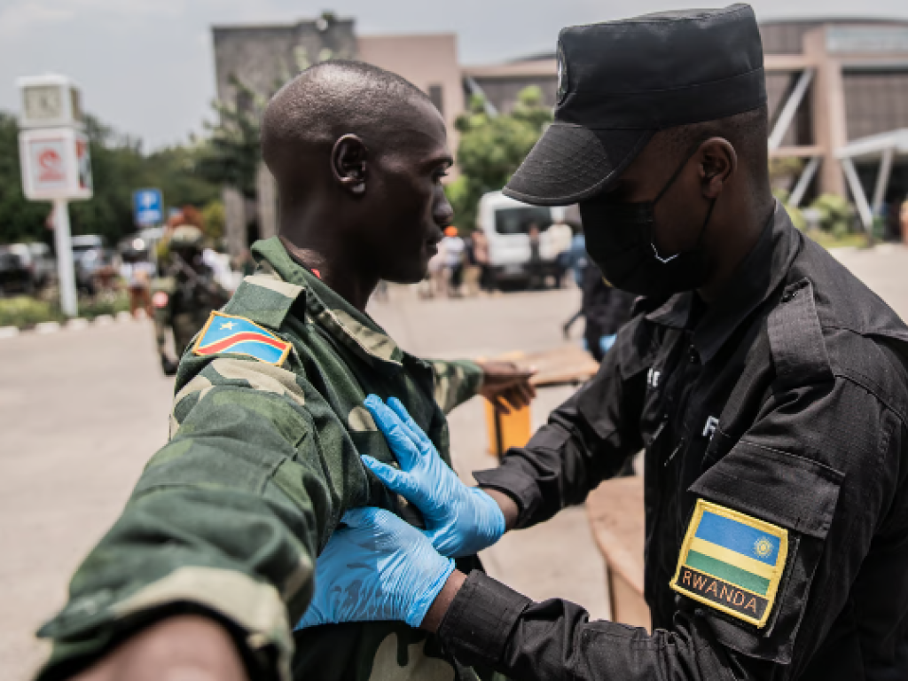 Des soldats des Forces démocratiques de libération du Rwanda (FDLR) sont fouillés par un fonctionnaire rwandais au principal poste frontière entre la RD Congo et le Rwanda, à Goma, le 1er mars 2025. © Jospin Mwisha / AFP