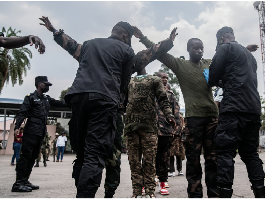 Des soldats des FDLR sont fouillés par un fonctionnaire rwandais au principal poste frontière entre la RDC et le Rwanda, à Goma, lors de leur rapatriement au Rwanda par le M23, le 1er mars 2025. © Jospin Mwisha / 