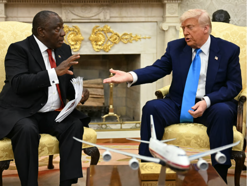 Le président américain, Donald Trump, remet des documents à son homologue sud-africain, Cyril Ramaphosa, lors de leur réunion dans le Bureau ovale de la Maison-Blanche, à Washington, le 21 mai 2025. © Jim Watson / AFP