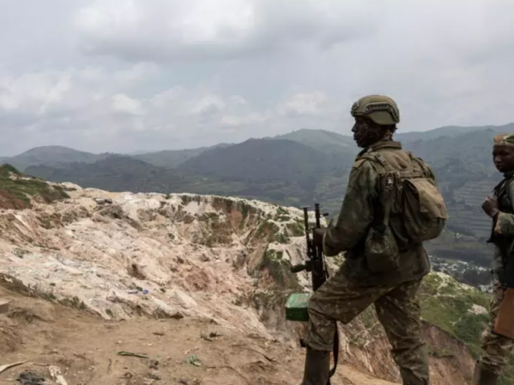 Des membres du M23 se tiennent devant les puits miniers de Rubaya, le 5 mars 2025. © AFP - CAMILLE LAFFONT